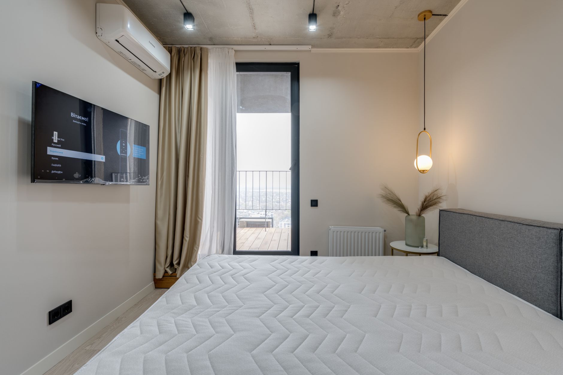 Các dấu hiệu nệm đã hư và cần thay mới - Minimalistic bedroom featuring a balcony, flat screen TV, and elegant lighting.