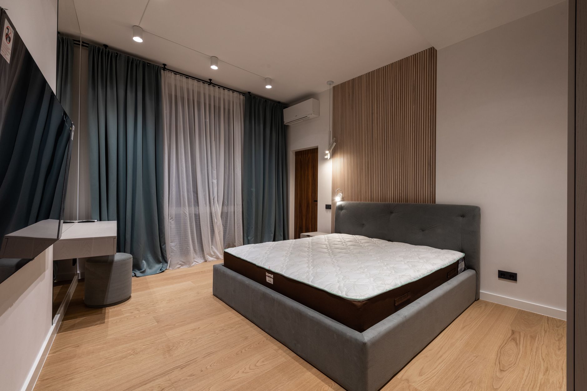 Nệm kháng khuẩn, nệm làm mát: công nghệ mới. - Modern TV set and comfy bed in stylish room decorated with lamps and curtains
