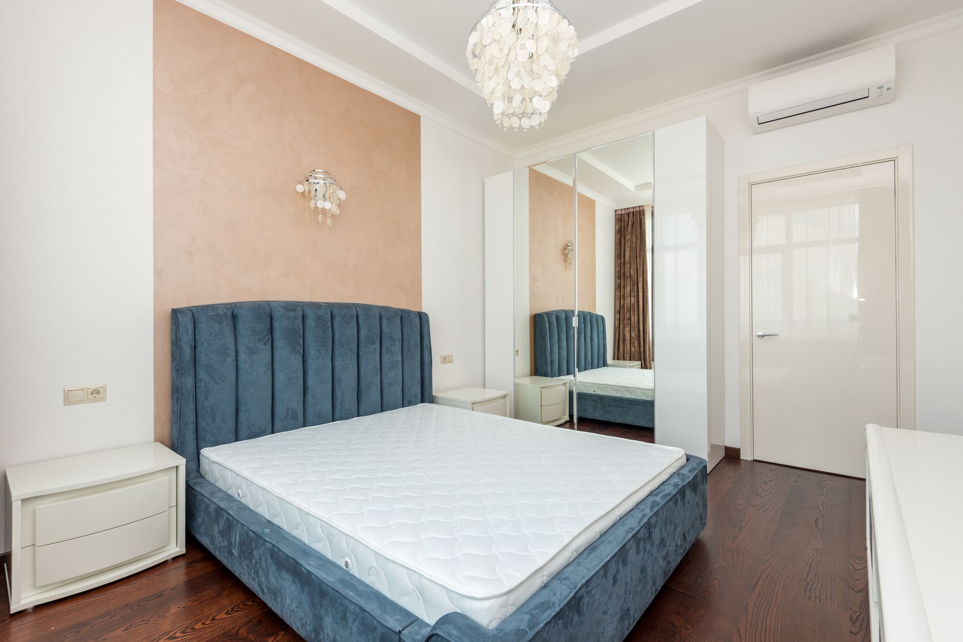 Nệm kháng khuẩn, nệm làm mát: công nghệ mới. - Elegant bedroom featuring a plush blue velvet bed and chic pendant light.