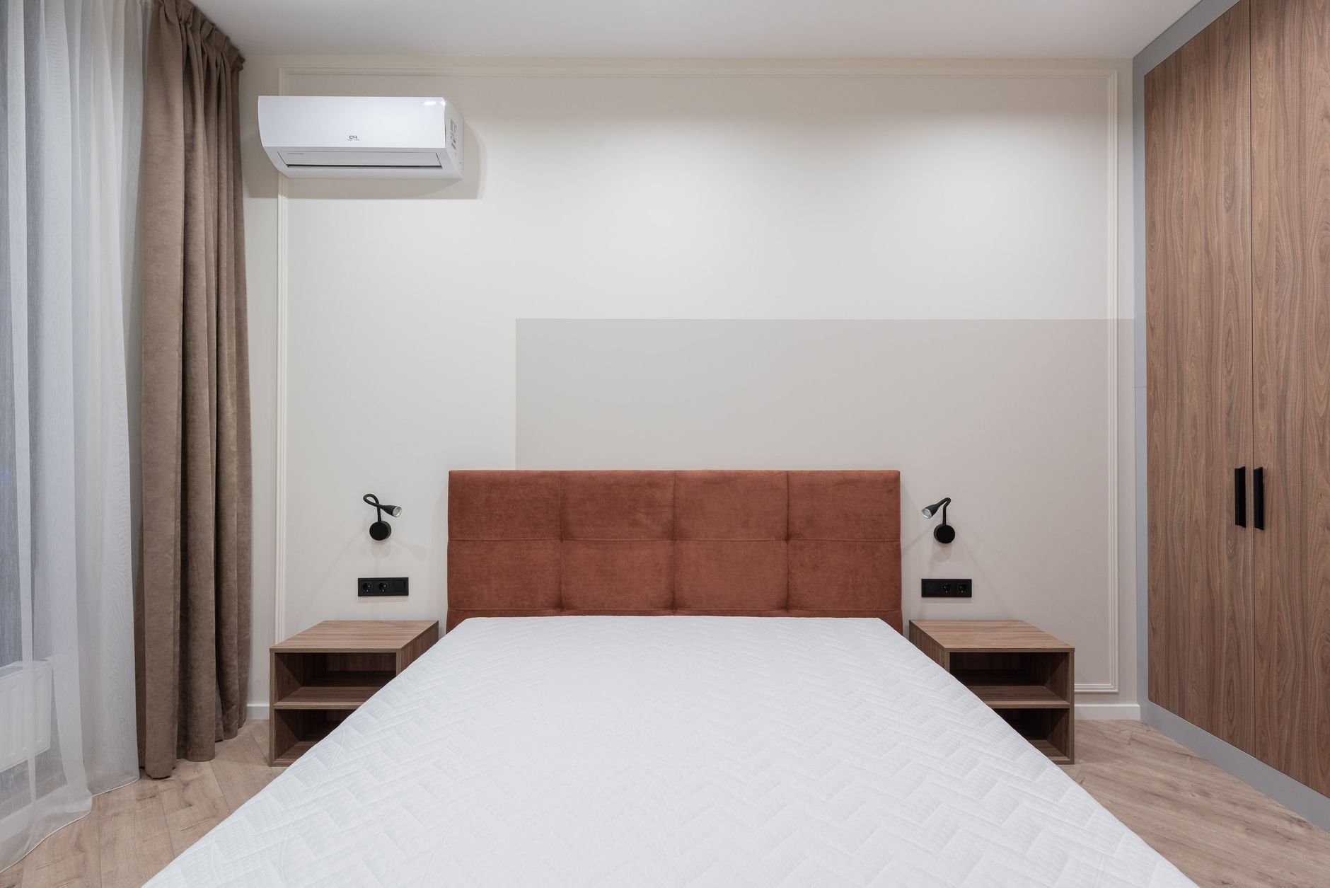 kéo dài tuổi thọ nệm - Modern bedroom interior with big comfortable bed and small bedside tables with large wardrobe in apartment