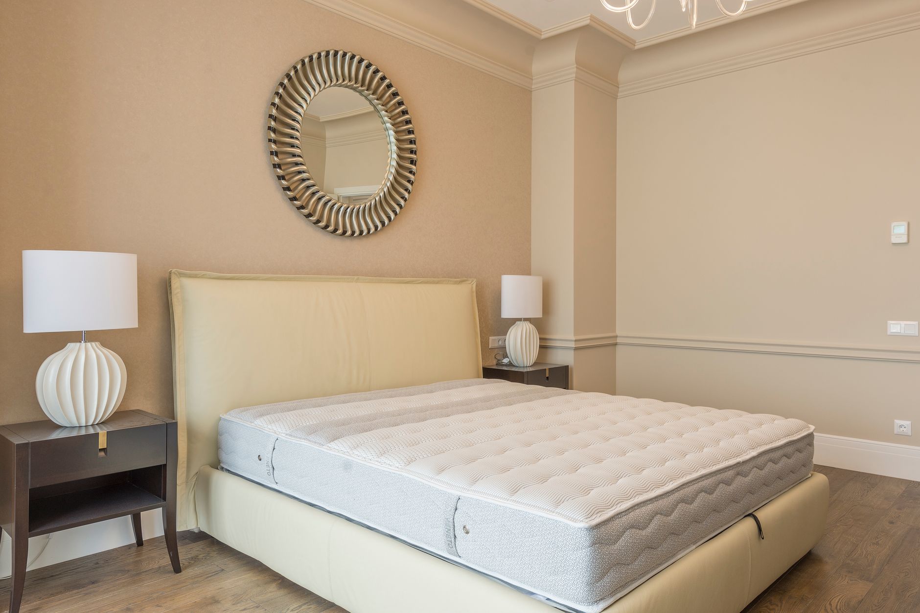 Các dấu hiệu nệm đã hư và cần thay mới - Spacious bedroom featuring modern decor, elegant lighting, and a plush bed with neutral tones.
